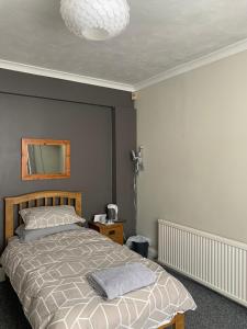 Bourton House في رغبي: غرفة نوم مع سرير ومرآة على الحائط