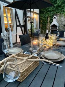 uma mesa de madeira com uma vela, pratos e copos em LA PETITE MAISON Fachwerkhaus am Rande des Sauerlandes in Warburg em Warburg