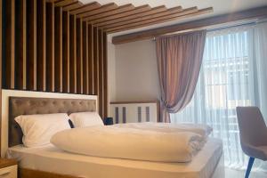 a bedroom with a large bed with a large window at Spreehotel Spremberg in Spremberg +10 photos