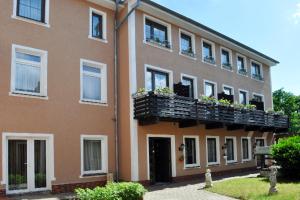 a building with a balcony with flowers on it at Spreehotel Spremberg in Spremberg