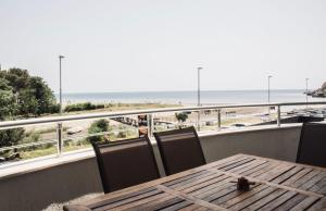 uma mesa e cadeiras numa varanda com vista para a praia em Apartments Art em Ulcinj