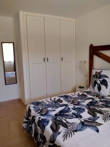 a bedroom with a bed with a black and white comforter at Apto Puipana in Corralejo