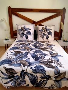 uma cama com um cobertor e almofadas azuis e brancas em Apto Puipana em Corralejo