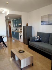 uma sala de estar com um sofá e uma mesa em Apto Puipana em Corralejo