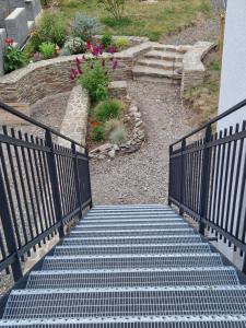 a set of stairs leading to a garden with flowers at Rebhaus Adams in Moselkern