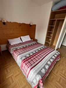 une chambre avec un lit avec une couverture dessus dans l'établissement Les Gentianes 1800, à Puy-Saint-Vincent 16 autres photos