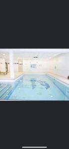 une grande piscine dans un bâtiment dans l'établissement Les Gentianes 1800, à Puy-Saint-Vincent