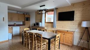 une cuisine et une salle à manger avec une table et des chaises dans l'établissement Les Gentianes 1800, à Puy-Saint-Vincent