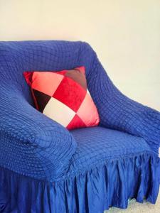a blue couch with a red and white pillow on it at Parkside 2 bedrooms appartment with encolsed garden in Largs