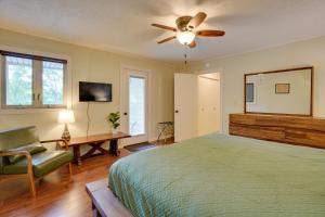 a bedroom with a bed and a ceiling fan at Lakefront Cadiz Home with Hot Tub! in Cadiz