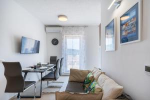 uma sala de estar com um sofá e uma mesa em Apartments Tatjana II em Cres