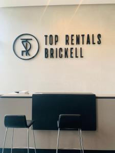 two chairs in front of a reception desk with a top rentals brickel sign at Top Rentals Brickell in Tigre