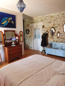 a bedroom with a bed and a stone wall at La ferme de Lec'h Hameury in Plestin-les-Grèves