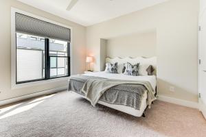 a white bedroom with a large bed and a window at Modern and Stylish Condo 5 Mi to Downtown Charlotte in Charlotte