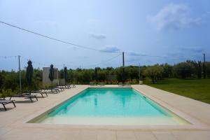 a large swimming pool with lounge chairs and tables at Agriturismo Casacchella in San Nico +20 photos