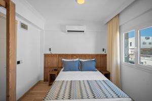 a bedroom with a bed with blue pillows and a window at Costa Viva Bodrum in Bodrum City