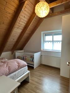 ein Schlafzimmer mit einem Kinderbett und einer Holzdecke in der Unterkunft Das Landhotel zur Mühle in Münster