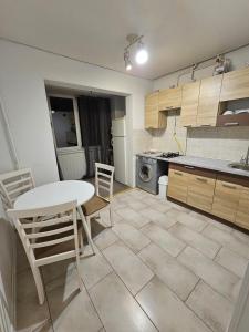 a kitchen with a table and chairs in a kitchen at Apartment on Constantin Negruzzi in Chişinău