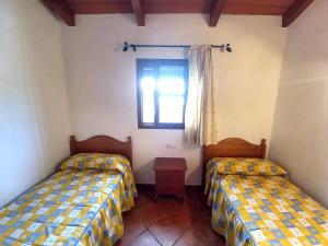 Pokój z 2 łóżkami i oknem w obiekcie Casa independiente con piscina - Villa Pintor w mieście Conil de la Frontera