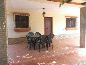 - une table et des chaises noires sur la terrasse dans l'établissement Casa independiente con piscina - Villa Pintor, à Conil de la Frontera