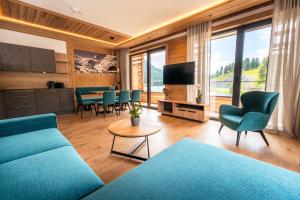 uma sala de estar com um sofá azul e uma mesa em Alpin Peaks em Turracher Hohe