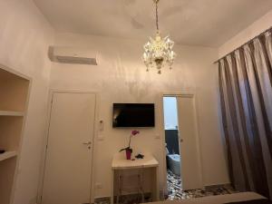 a living room with a television and a chandelier at Al Mare 54 Luxury Guest House in Lido di Camaiore