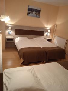 a hotel room with two beds and two lamps at Auberge du pont canal in Briare