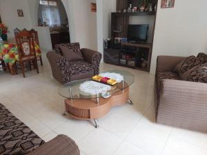 a living room with a glass table and chairs at Maison Hibiscus in Mare Jocquot