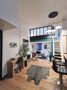 a living room with a staircase and a rug at Tout confort proche transport - Au Coin du Château in Nantes