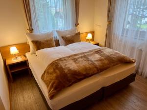 a large bed in a bedroom with two lamps at Residence Palmai in Ortisei