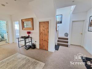 a living room with a wooden door and stairs at 4 bedroom 'Screen6' by Tunnels Beaches in a historic building in Ilfracombe