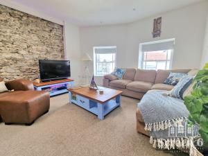 a living room with a couch and a tv at 4 bedroom 'Screen6' by Tunnels Beaches in a historic building in Ilfracombe