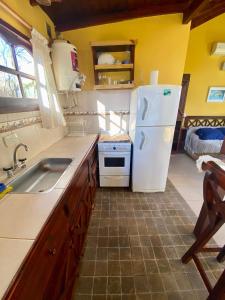 a kitchen with a white refrigerator and a sink at El Quincho in Costa del Este