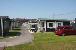 a red car parked in front of a row of houses at Vacation house MAX for 4 persons, 350 m from the sea, in Pollentier Middelkerke Park in Middelkerke