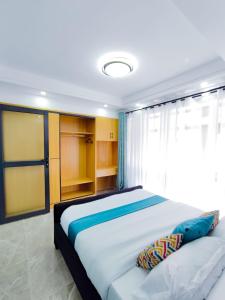 a bedroom with a large bed and a window at Heartland Gardens Apartments Kilimani Nairobi in Nairobi