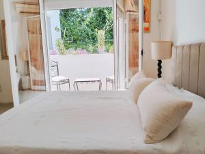 a bedroom with a white bed and a large window at Spacieuse et Cosy in El Haouach