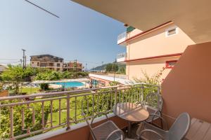 a balcony with chairs and a view of a pool at Kalias Hotel in Vasiliki