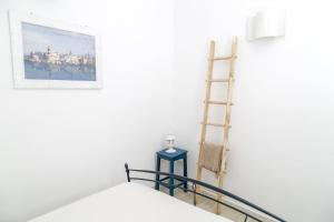 een kamer met een ladder, een bed en een foto bij Borgo Albergo Capozzi 41 in Monopoli