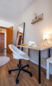 einen Schreibtisch mit einem weißen Stuhl und einem Spiegel in der Unterkunft City Oasis: Stylish Retreat in the Heart of Sofia in Sofia