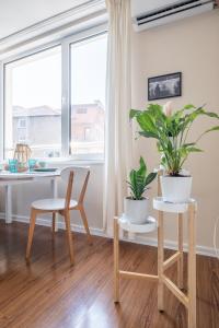 ein Wohnzimmer mit einem Tisch, Stühlen und einem Fenster in der Unterkunft City Oasis: Stylish Retreat in the Heart of Sofia in Sofia