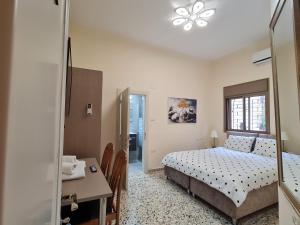 a bedroom with a bed and a table and a desk at Rizik's Guest House in Nazareth