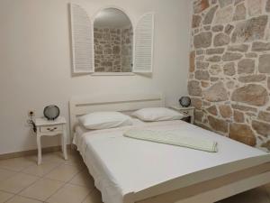 2 camas en una habitación con una pared de piedra en Holiday home Barbaroša, en Sveti Filip i Jakov
