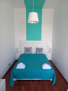 1 dormitorio con cama azul y pared azul en Sole amarè guest house, en Bari