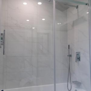 ein Bad mit einer Dusche und einer Glastür in der Unterkunft Le Chalet Amical in Saint-Paulin