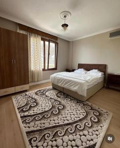 a bedroom with a bed and a large rug at Zeytinlik Suits in Akcaabat