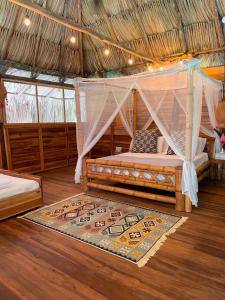 a bedroom with a bed with a mosquito net at Salvia Madre in Santa Marta