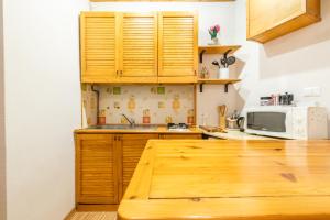 - une cuisine avec des placards en bois et un four micro-ondes dans l'établissement Le Antiche Mura, à Lucques