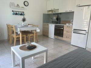 cocina con mesa y nevera blanca en Pinezići apartman Niccole en Pinezici