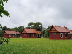 a group of red houses in a field at Toek Chha Temple Resort in Kampong Cham