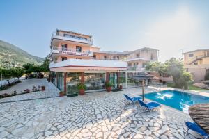 a hotel with a swimming pool in front of a building at Kalias Hotel in Vasiliki